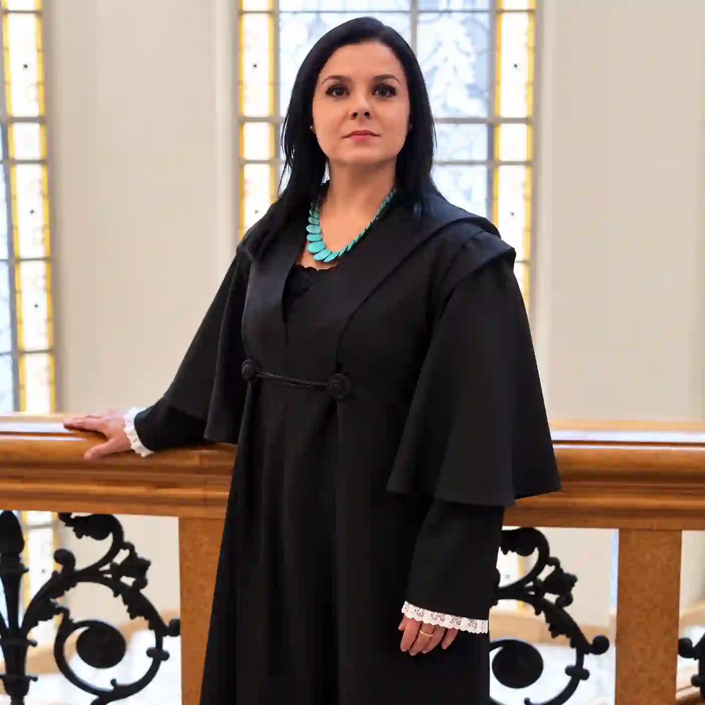 Dra. Vanessa Moliani da Rocha, advogada especialista em Direito de Família e Sucessões, em pé junto a um corrimão de madeira